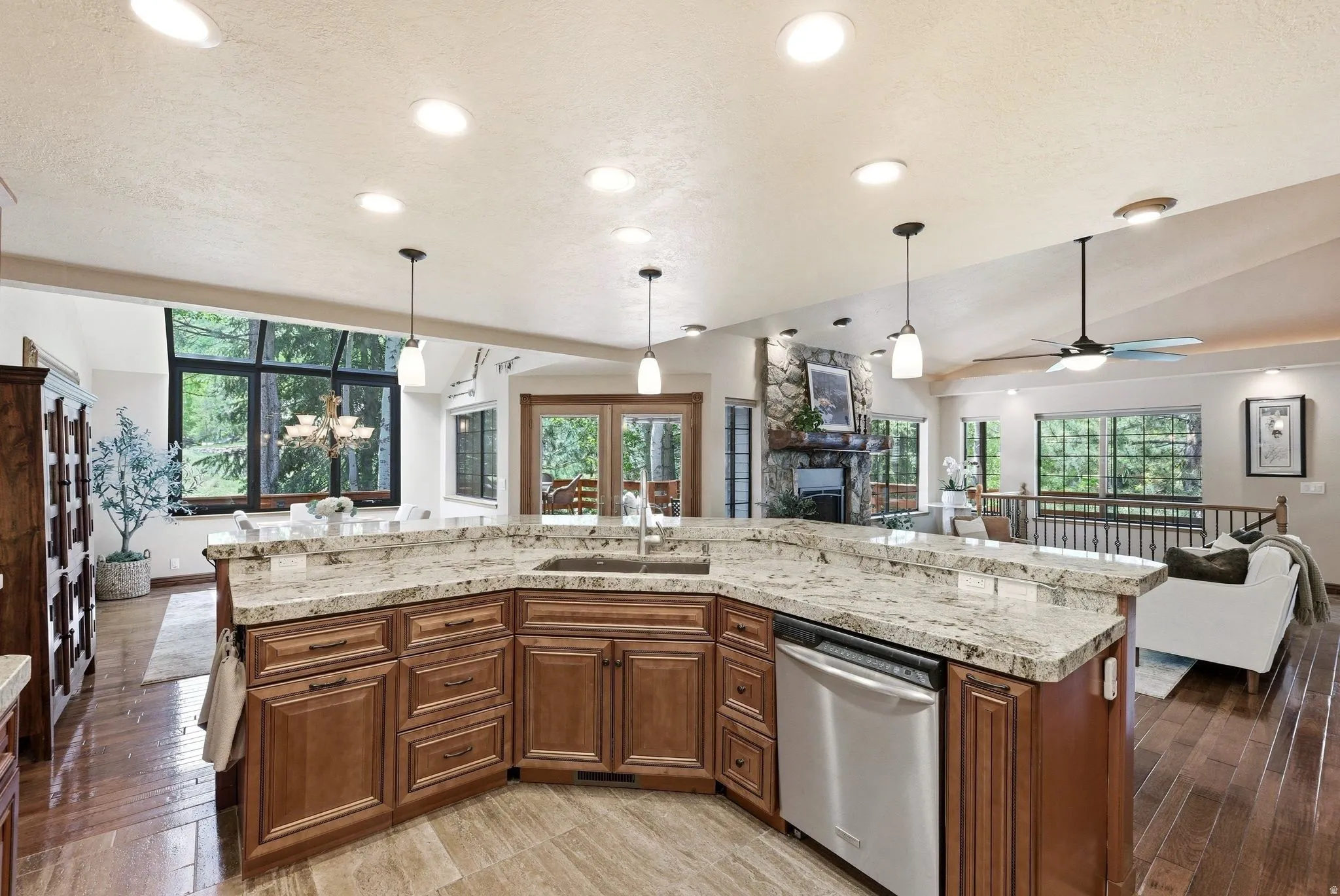 Kitchen island with granite countertops, integrated stainless steel dishwasher, and a double basin sink
