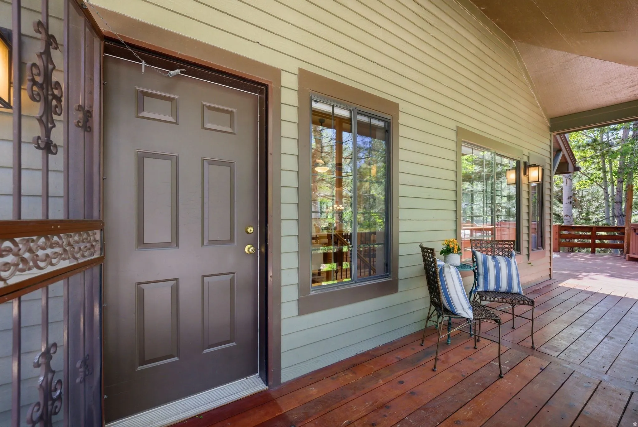 Expansive covered porch featuring wood-finish flooring and a light green horizontal siding exterior