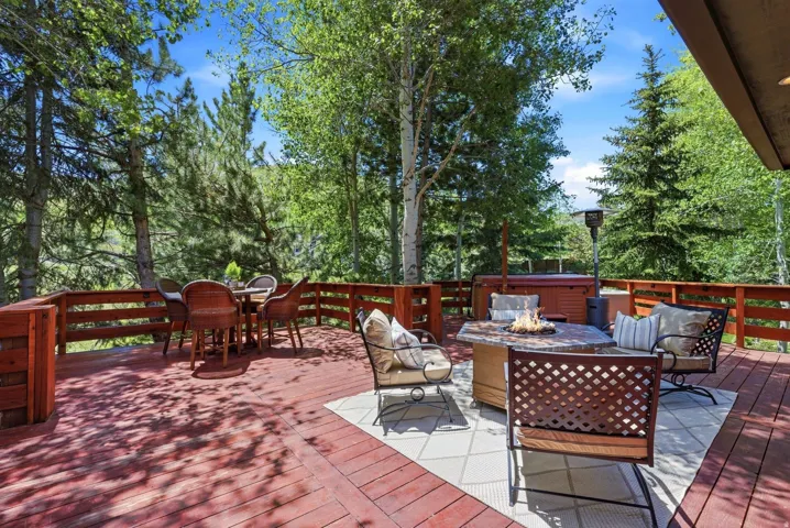 Spacious wooden deck featuring a built-in hot tub and perimeter railing