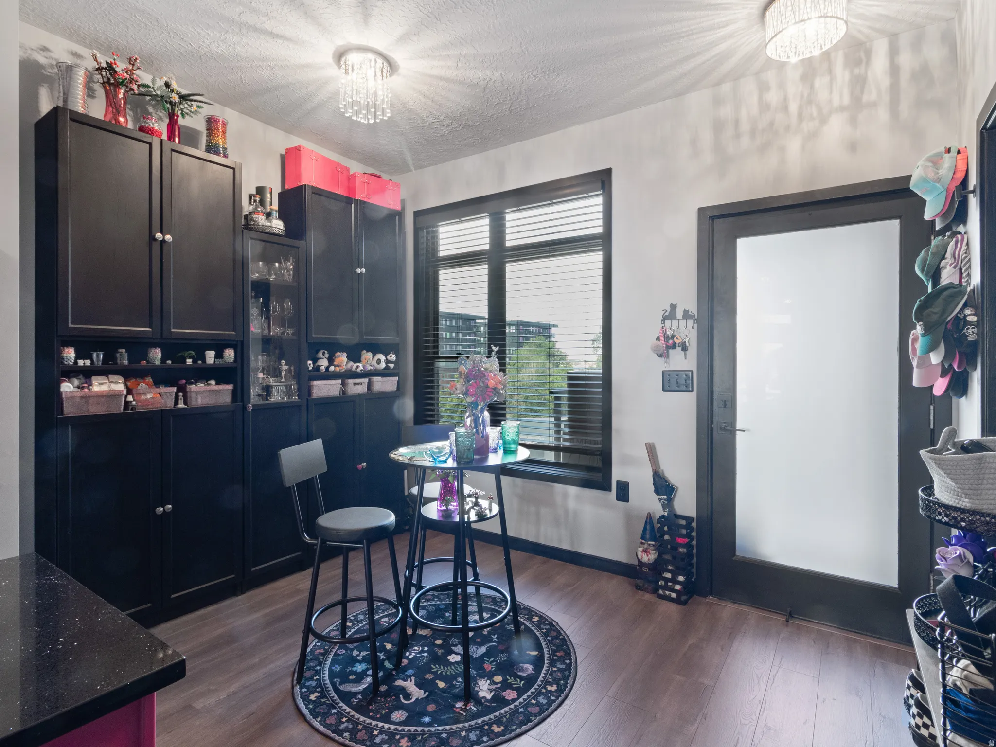Room featuring wood-finish flooring and two contemporary crystal chandeliers