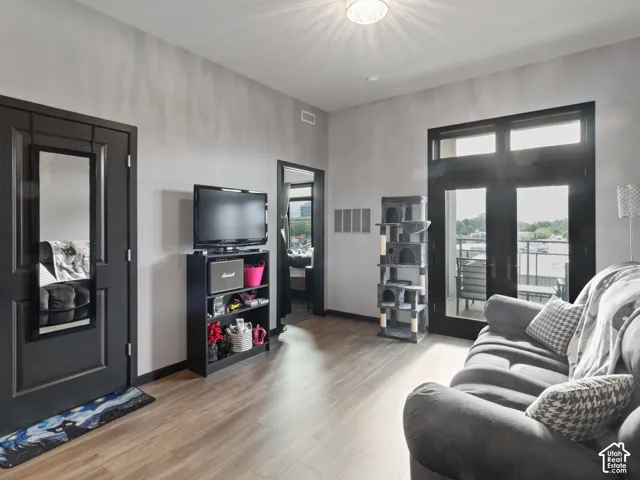 Living area featuring wood-finish flooring, light grey walls, and a ceiling-mounted light fixture