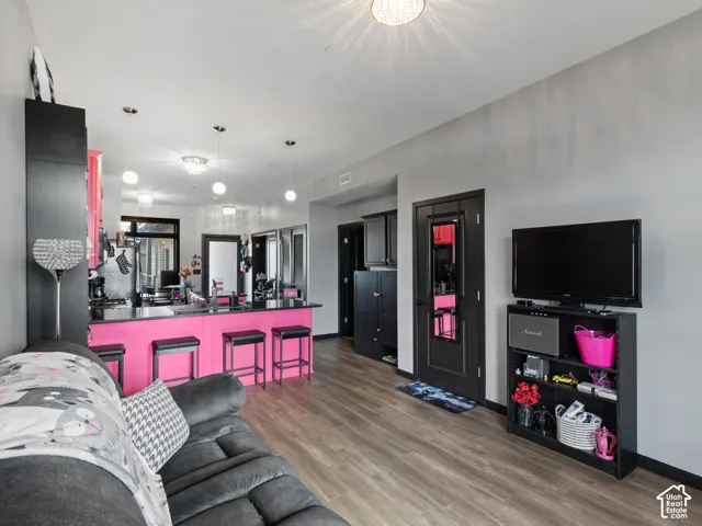 Open-concept living area featuring wood-finish flooring and a kitchen island with a black countertop