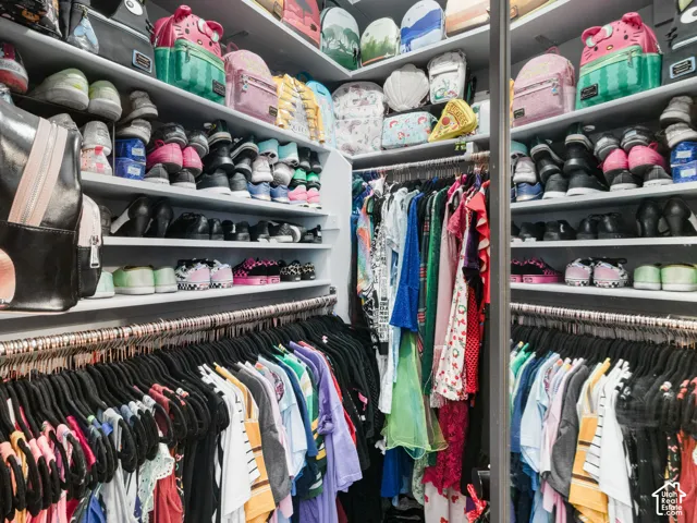 Built-in closet system featuring multiple shelving units, integrated hanging rods, and a reflective panel