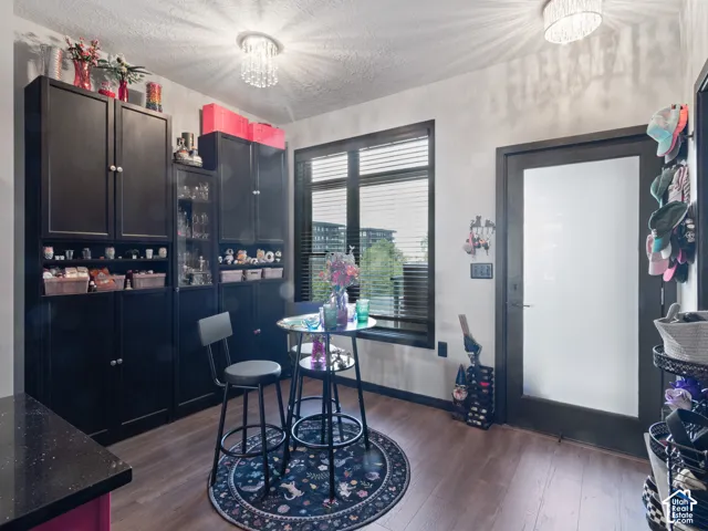 Room featuring wood-finish flooring and two contemporary crystal chandeliers