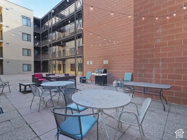 Expansive communal patio featuring paving stones and string lighting