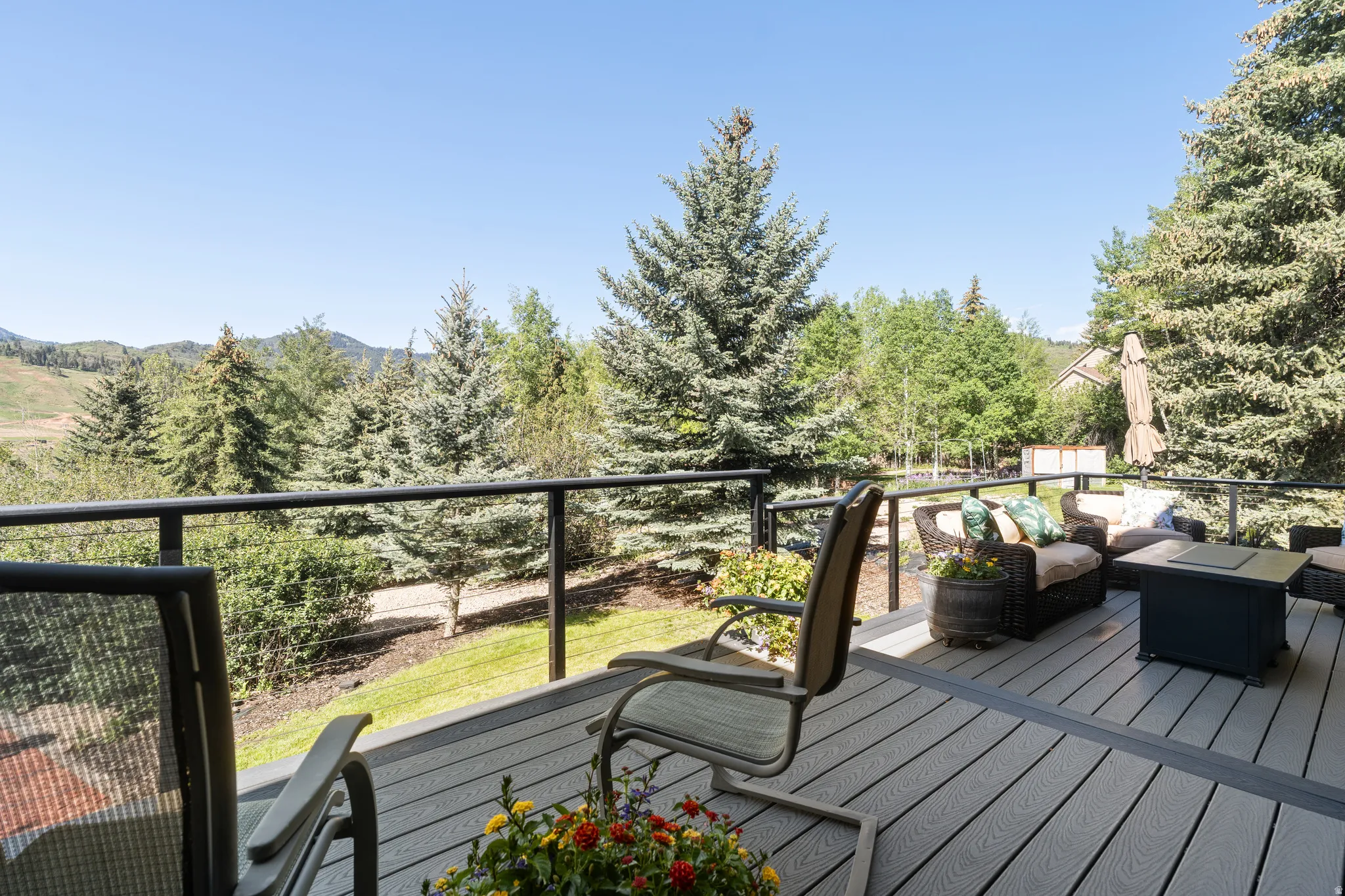 Spacious outdoor deck featuring composite decking and black metal railings