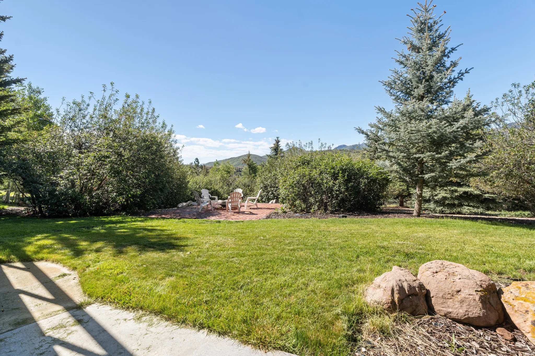 Expansive lawn bordered by mature trees and shrubs