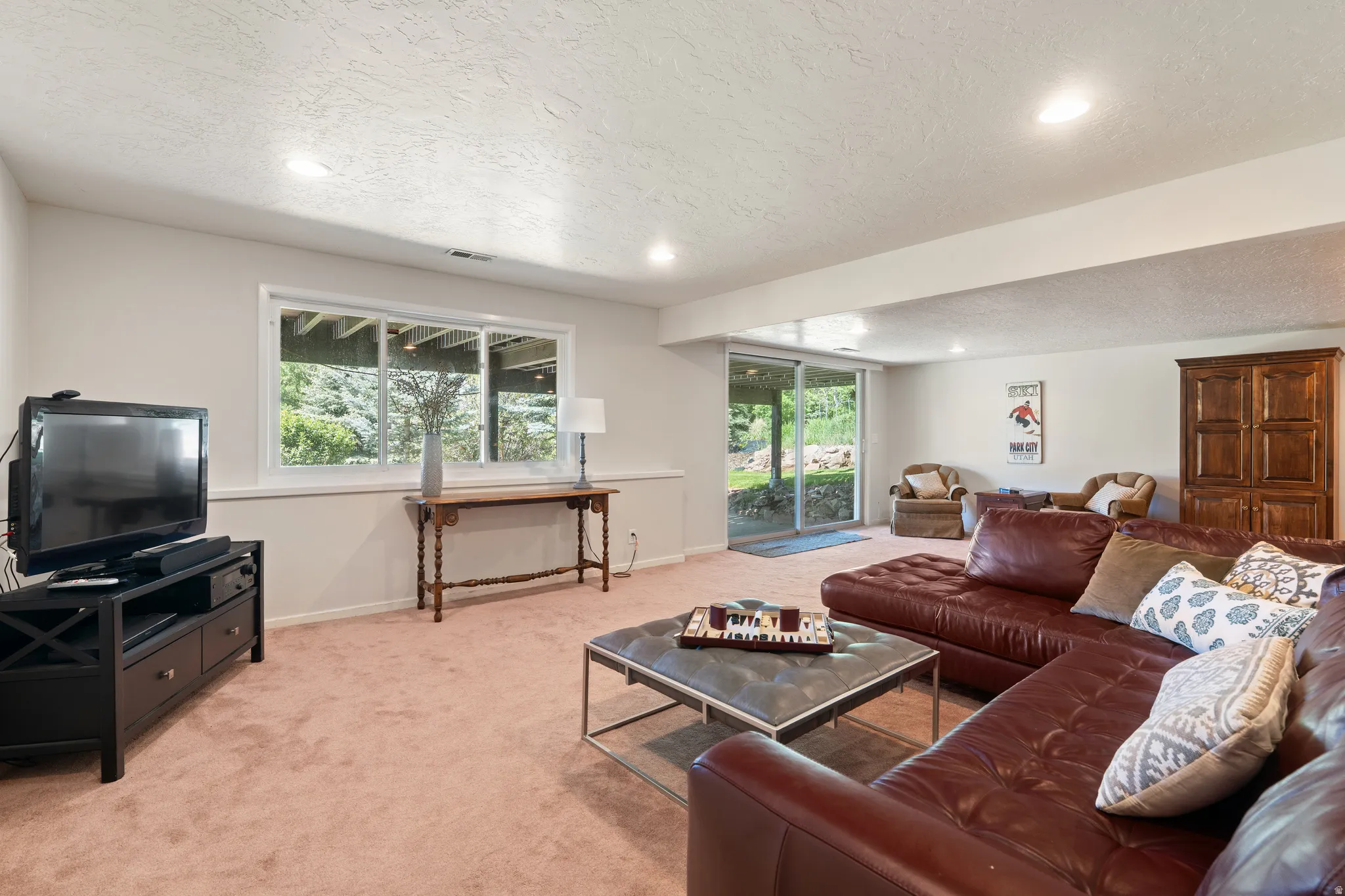 Lower-level living area with recessed lighting, carpeted flooring, and light-toned walls