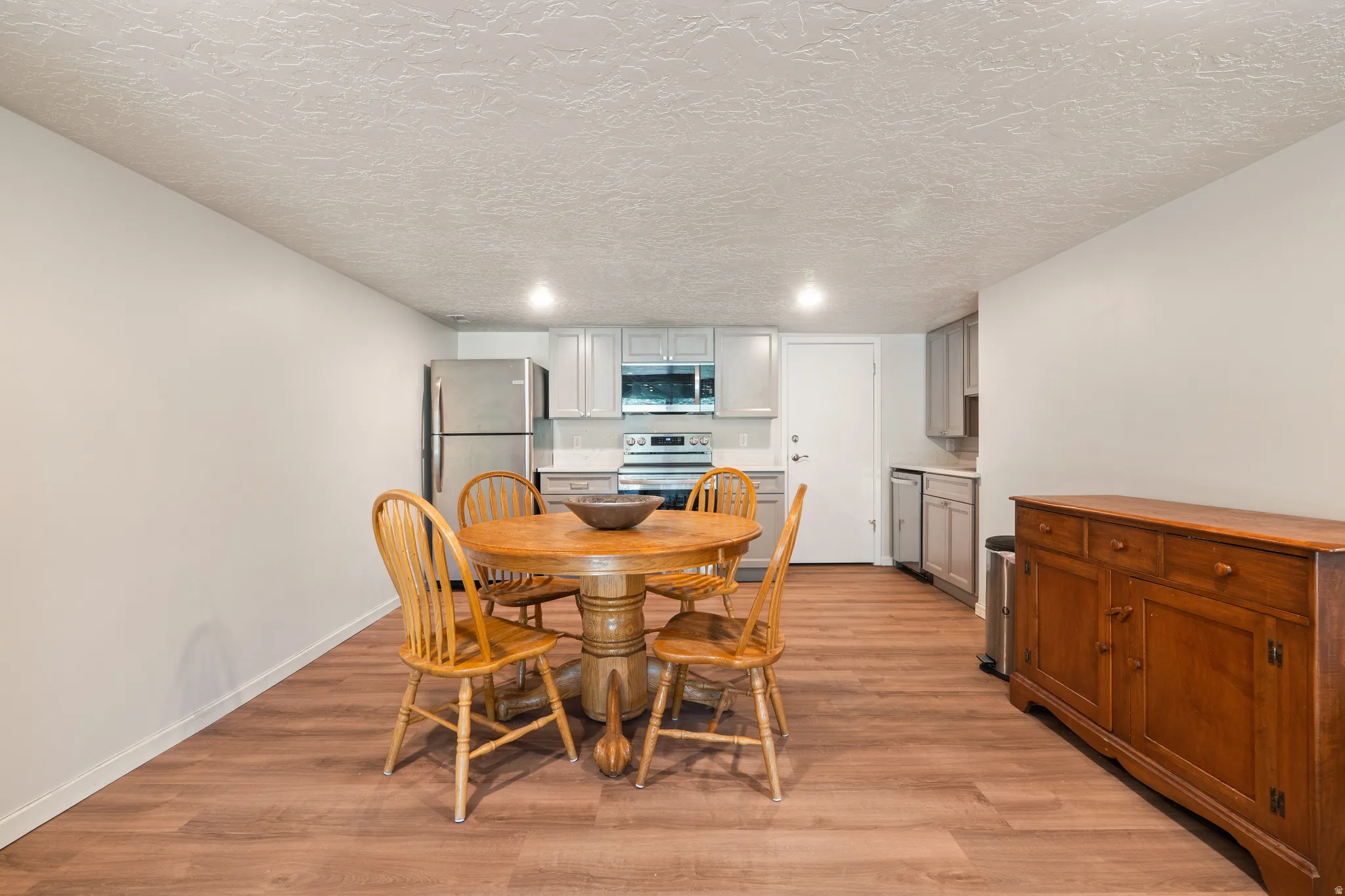 Open-concept living space with wood-finish flooring extending into the kitchen area