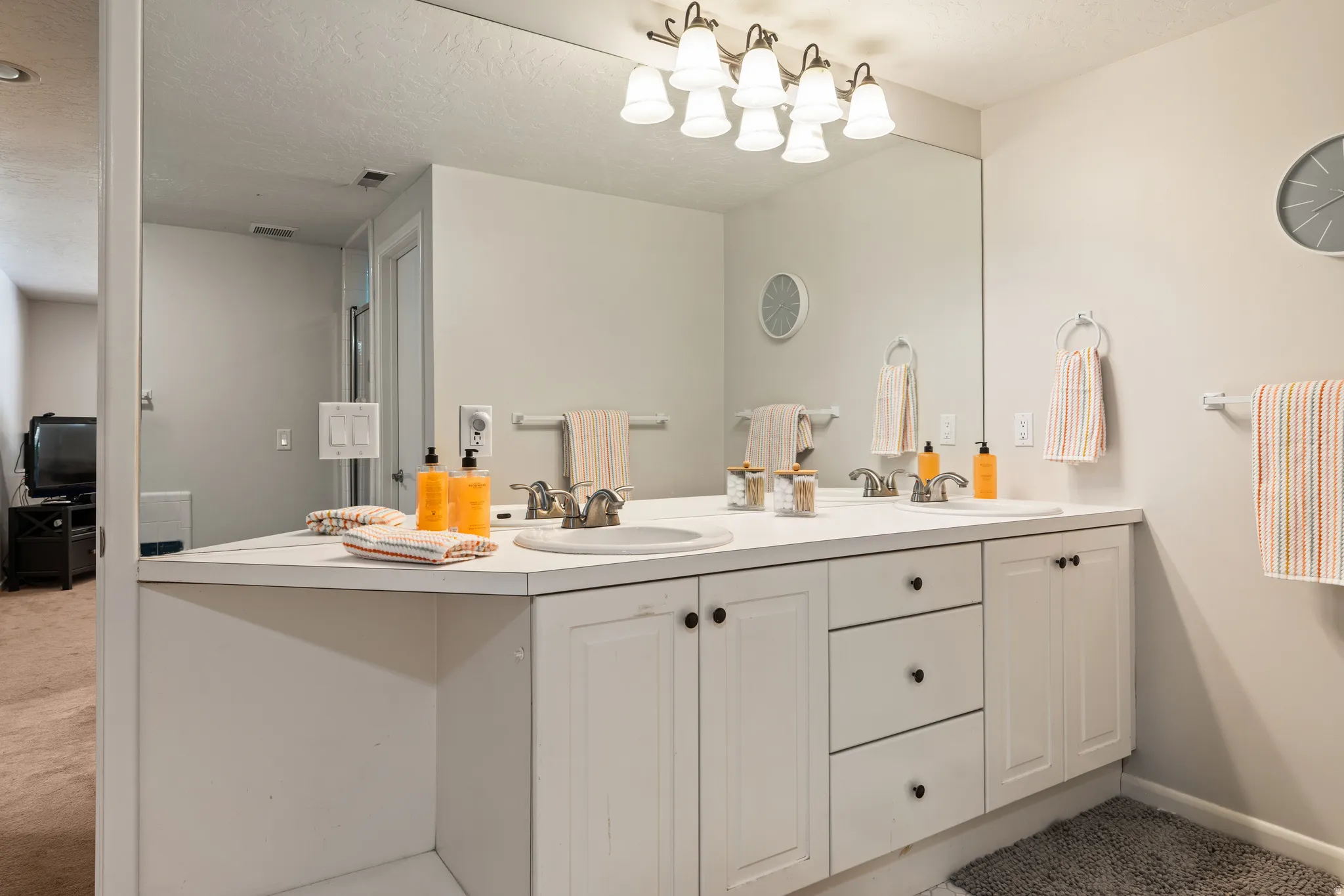 Dual sink vanity featuring white cabinetry and black hardware