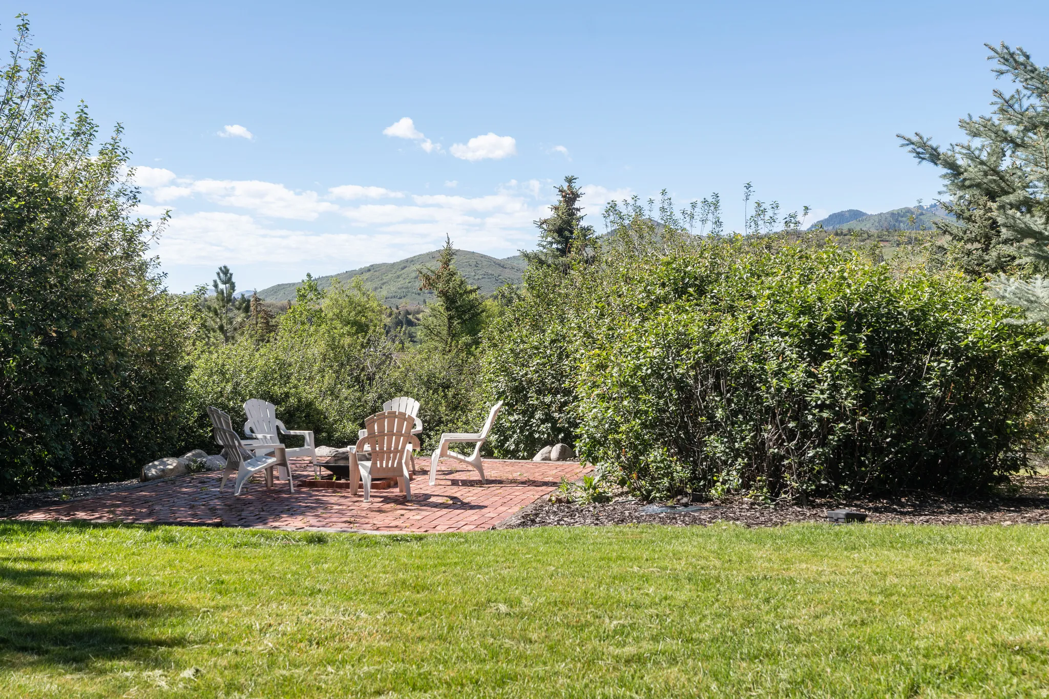 Expansive grassy area with a brick paver patio