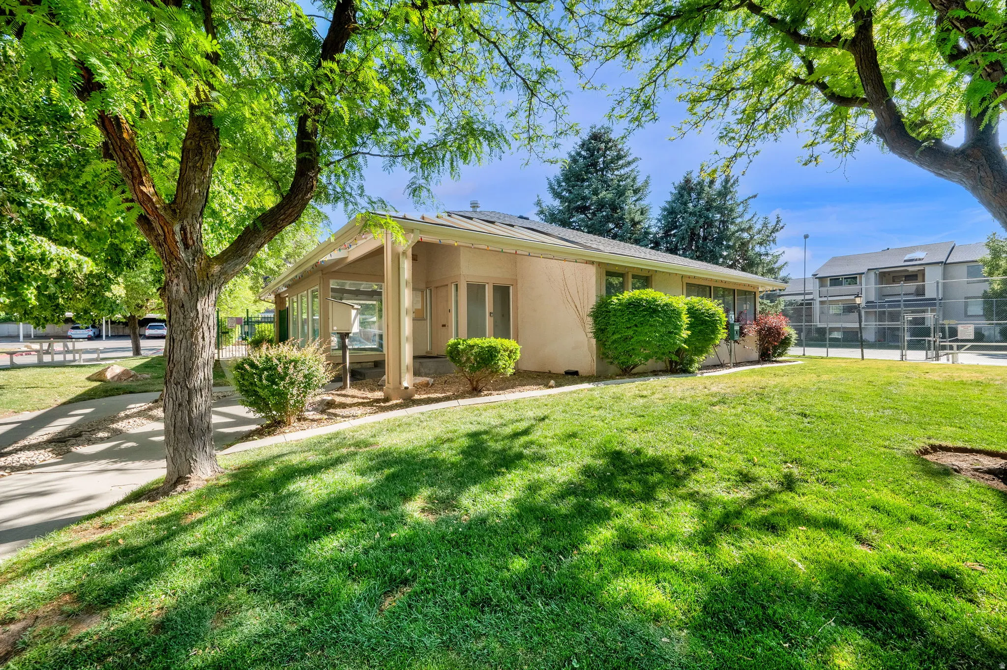 Single-story property with a covered patio, neutral exterior finish, and a sloped lawn