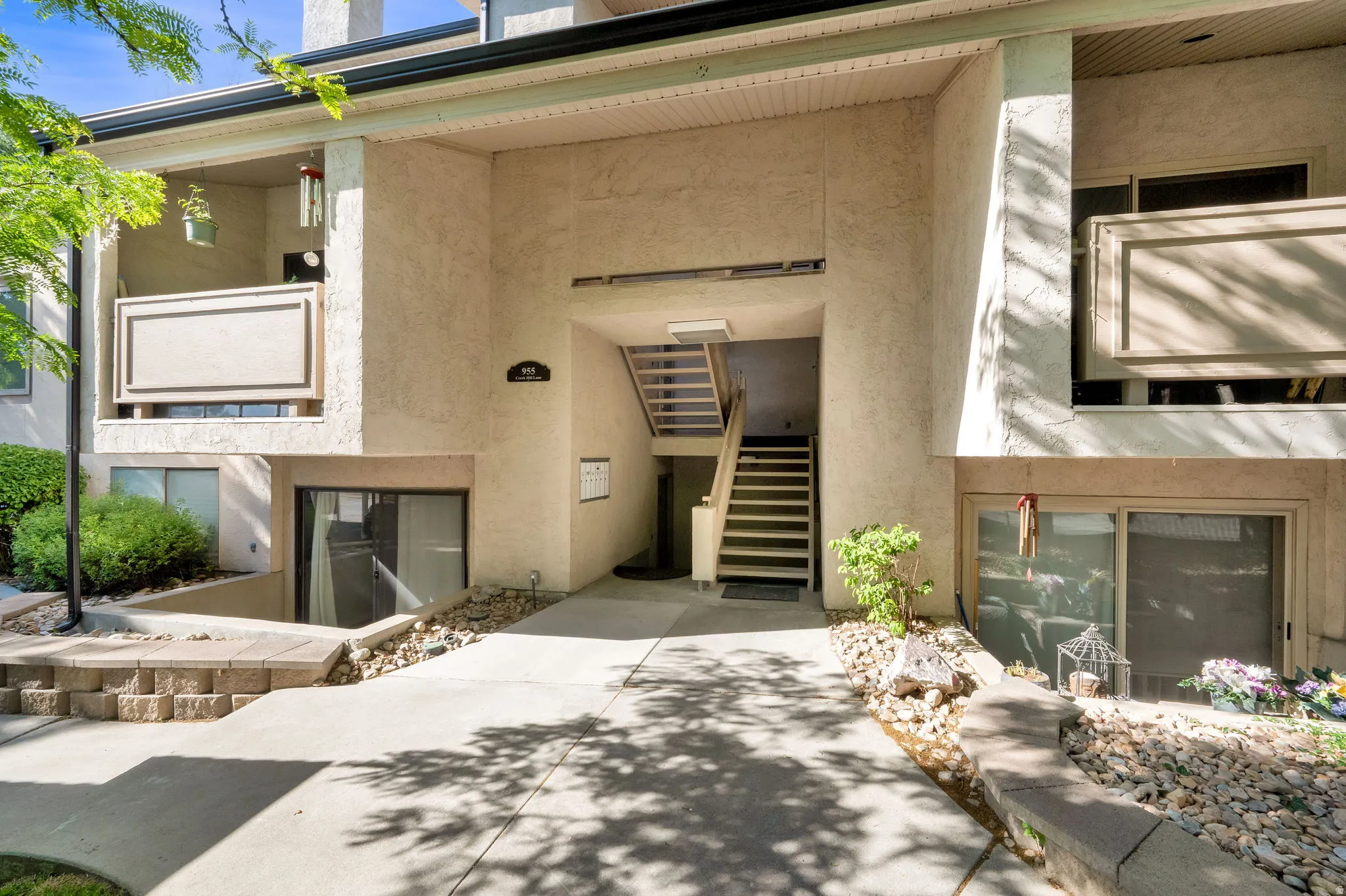 Multi-level exterior entrance featuring stucco siding and an integrated staircase
