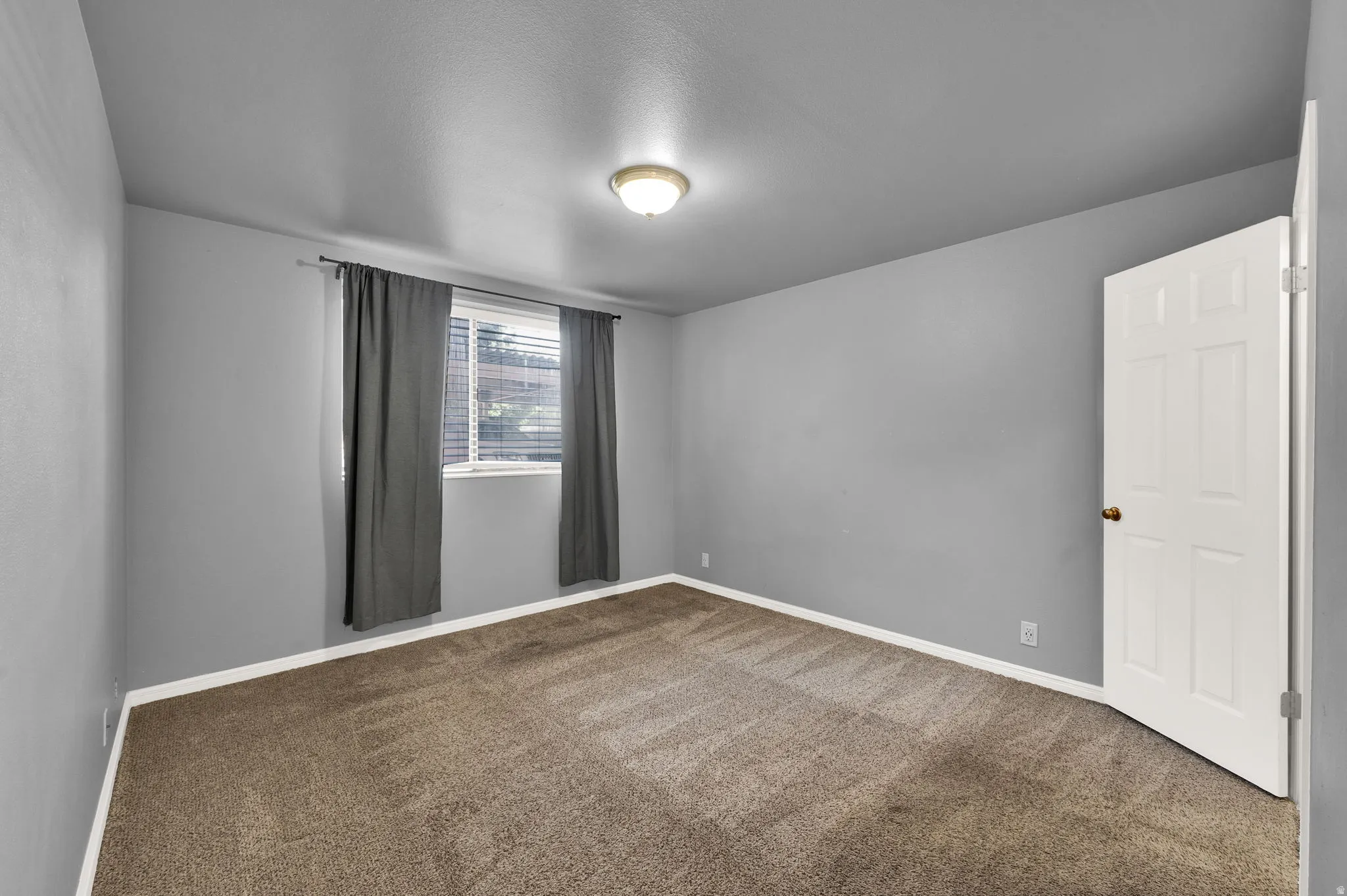 Interior room with neutral gray walls and brown patterned carpeting