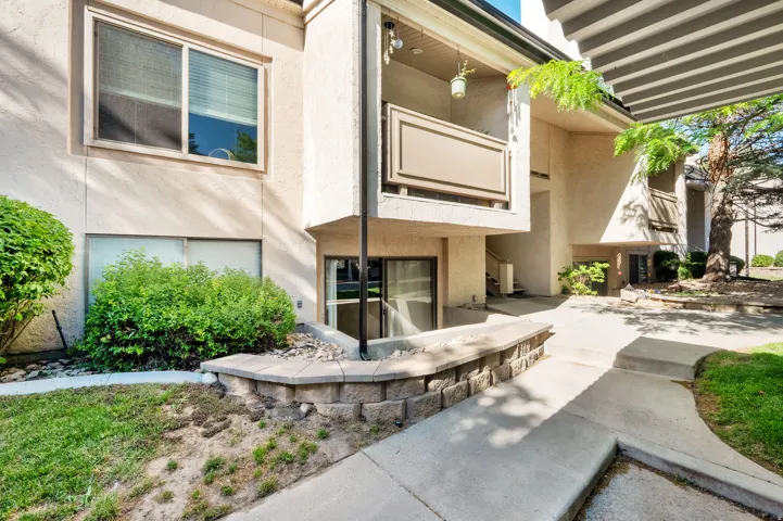 Exterior stucco facade with a private balcony featuring a privacy panel