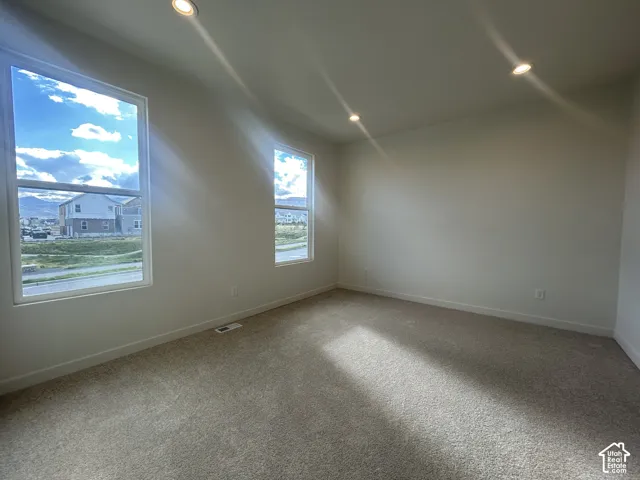 Neutral interior featuring recessed lighting, wall-to-wall carpeting, and dual windows with mountain scenery