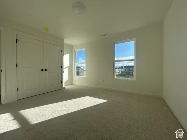 Neutral-toned wall-to-wall carpeting, dual-pane windows, and a closet with double-panel doors