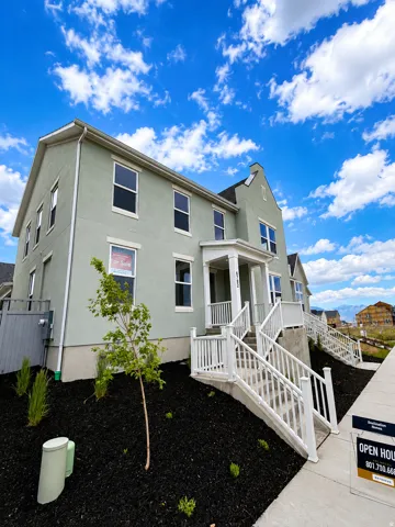Two-story stucco exterior with white trim and a covered front porch featuring white railings