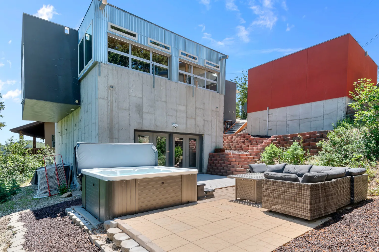 Outdoor patio featuring a built-in hot tub and stone paver flooring