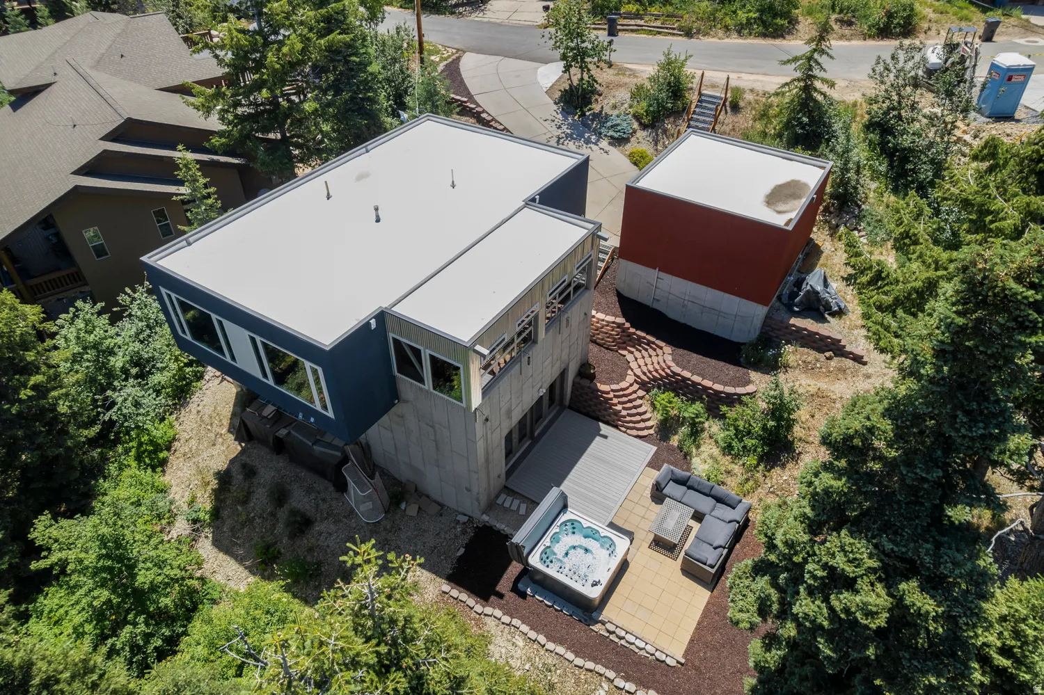 Contemporary multi-level exterior with flat rooflines, a private outdoor patio, and a separate detached structure