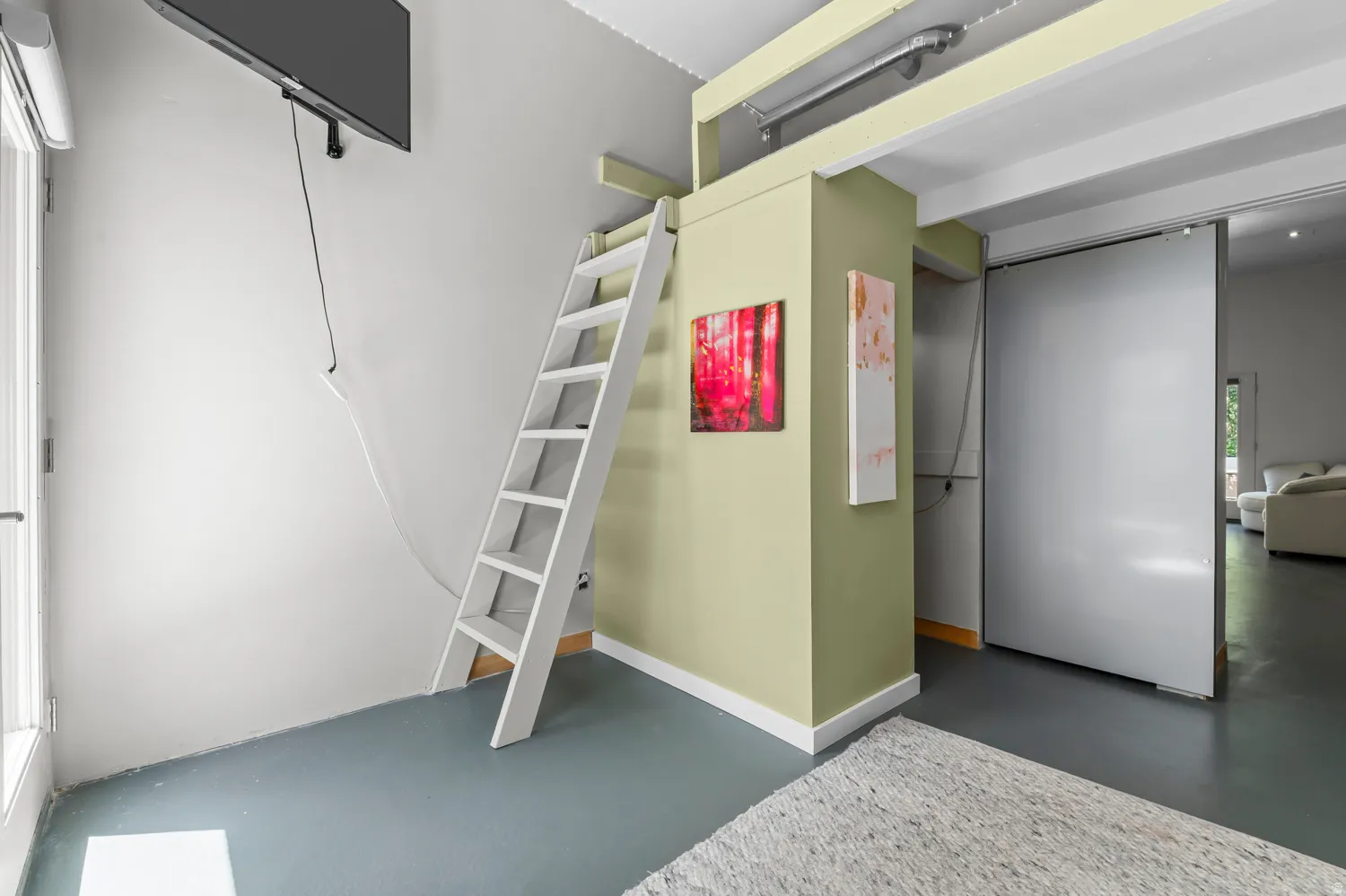 Mezzanine access ladder with neutral wall tones and dark grey flooring