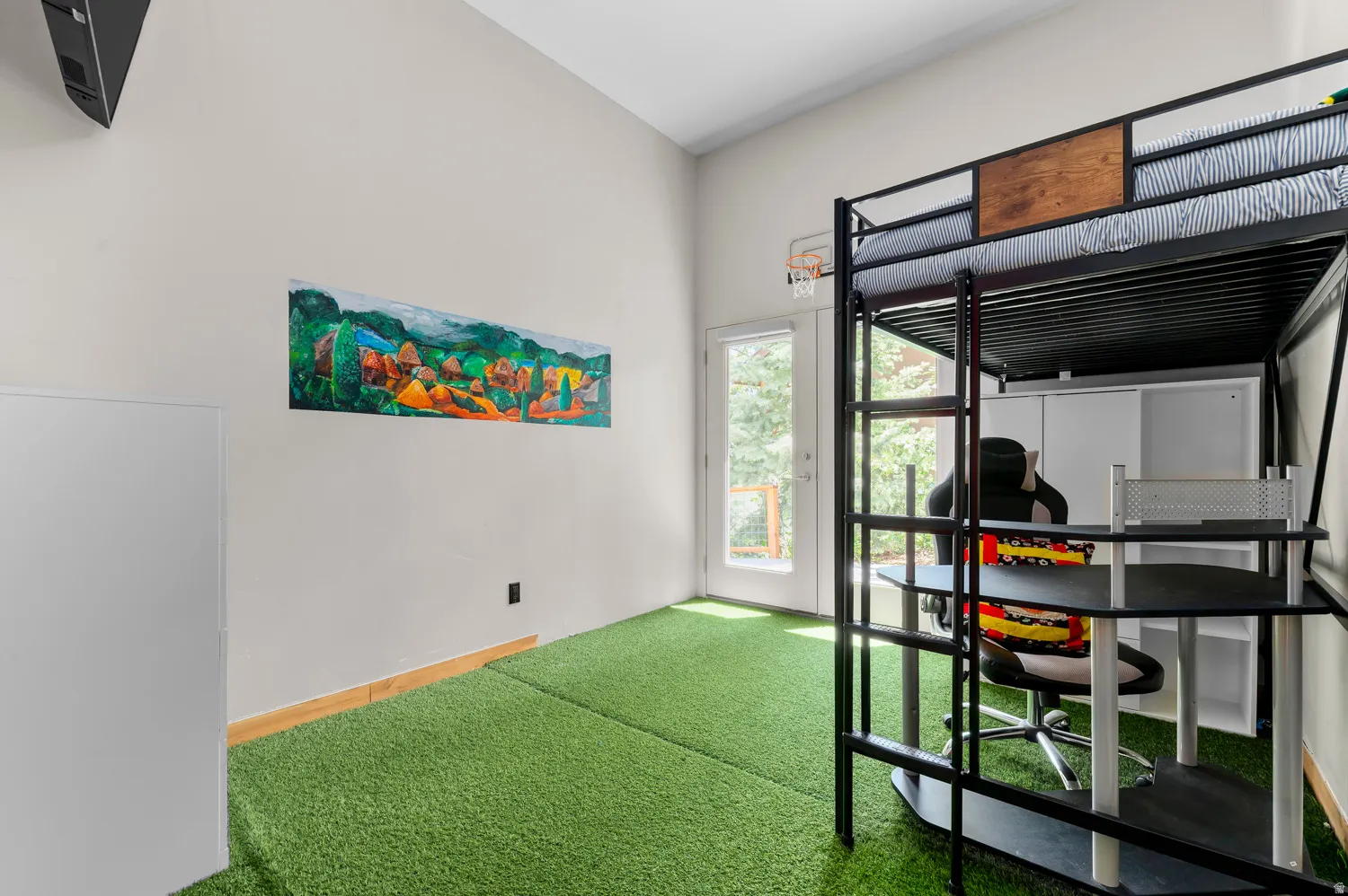 Room featuring an artificial turf floor and a white painted wall