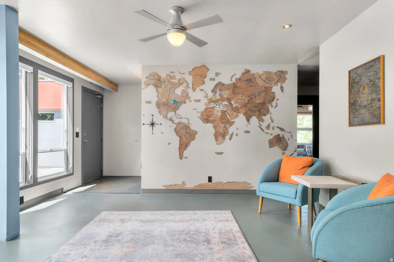 Open-concept space featuring light gray flooring, white walls, and a contemporary ceiling fan with integrated lighting