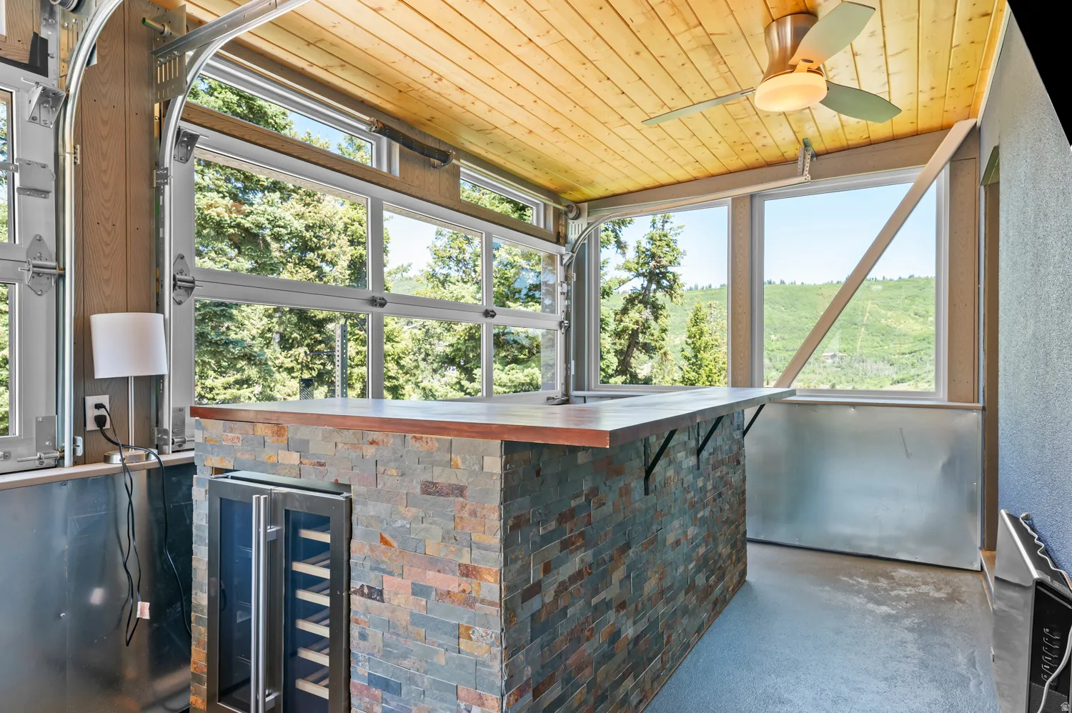 Entertainment space featuring a stacked stone bar with a wood-finish countertop, integrated beverage cooler, and a single basin sink