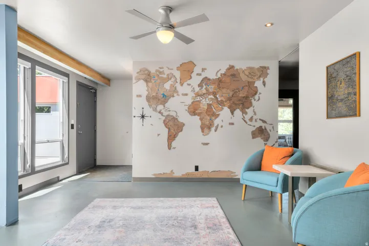 Open-concept space featuring light gray flooring, white walls, and a contemporary ceiling fan with integrated lighting