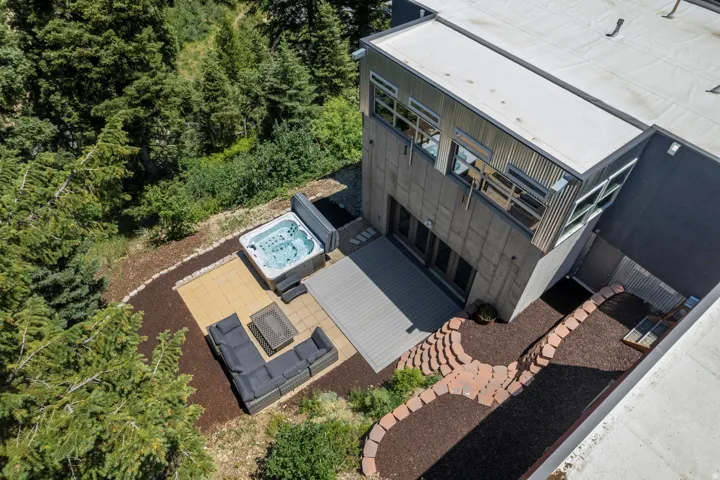 Modern exterior featuring a composite deck, an integrated hot tub, and a stone paver patio