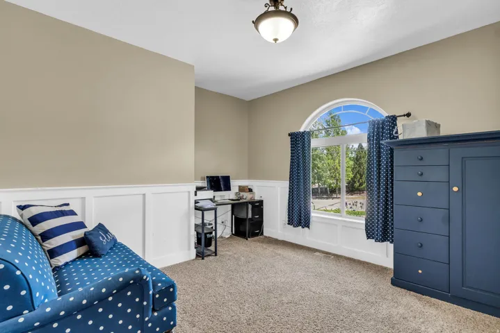 Carpeted room with a half-arch window, white wainscoting, and a ceiling-mounted light fixture