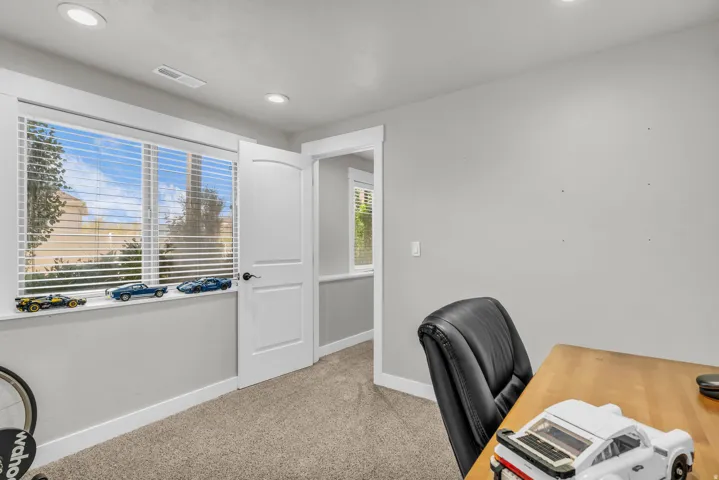 Room featuring a large window with white blinds, neutral carpeting, recessed lighting, and crisp white trim