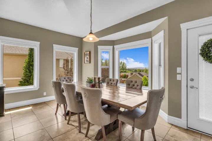 Dining area featuring a bay window with multiple panes, tile flooring, and a glass-paneled exterior door