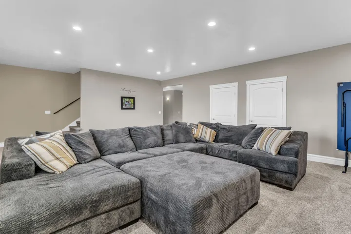 Spacious room featuring neutral-toned walls, recessed lighting, and carpet flooring