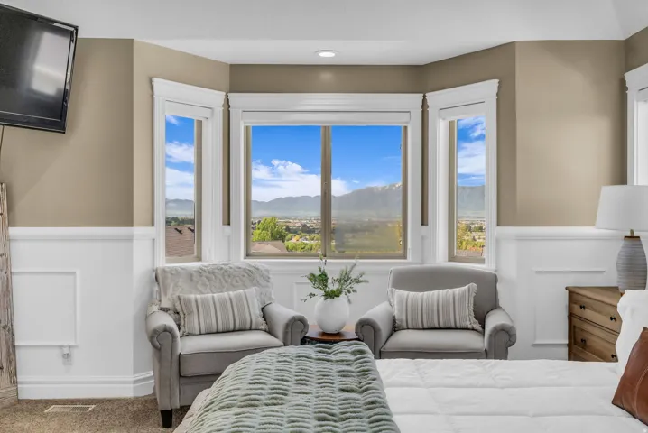 Bay window with mountain scenery, framed by extensive white trim and wainscoting