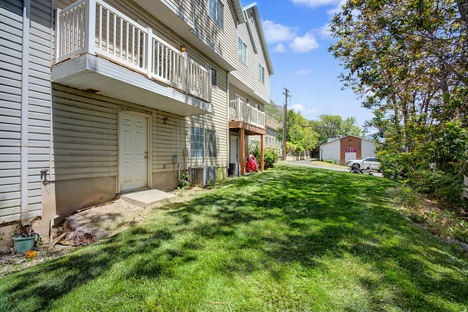 Expansive green lawn with established trees bordering the property
