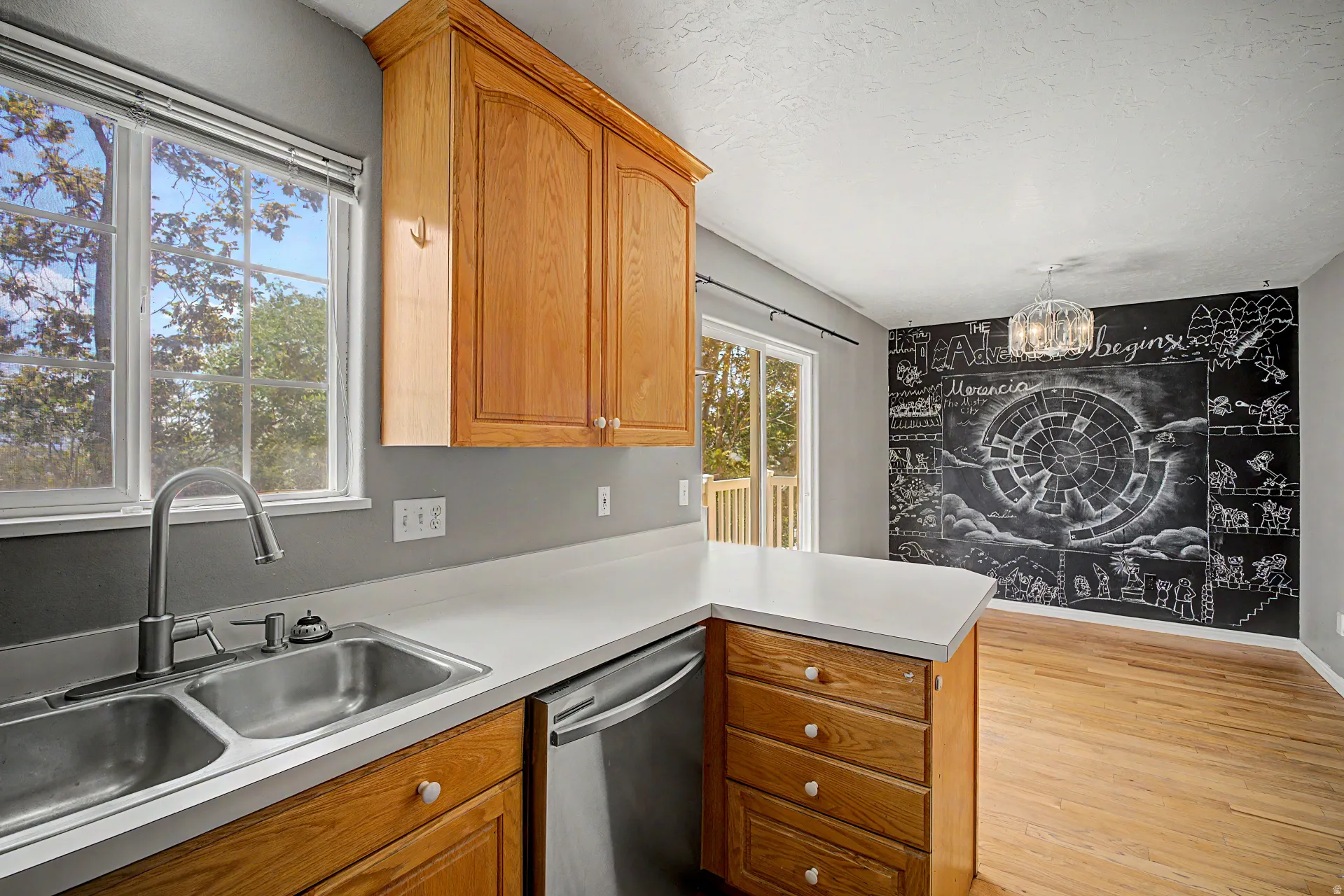 Kitchen featuring light wood cabinetry, a double basin stainless steel sink, and light countertops