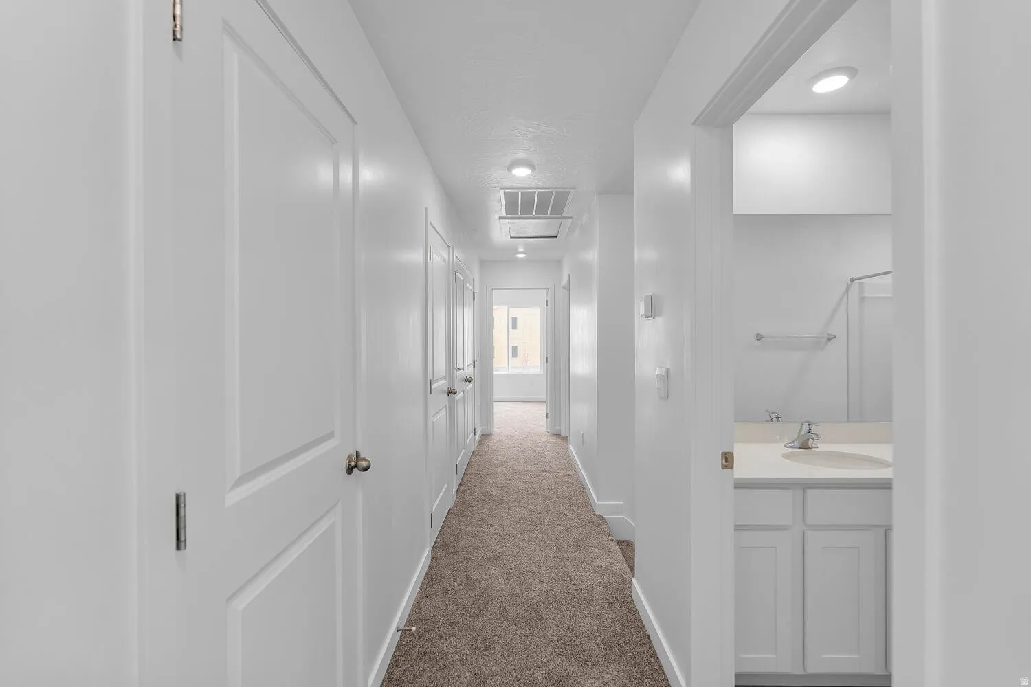 Hallway featuring carpet flooring, crisp white walls, recessed lighting, and white paneled doors