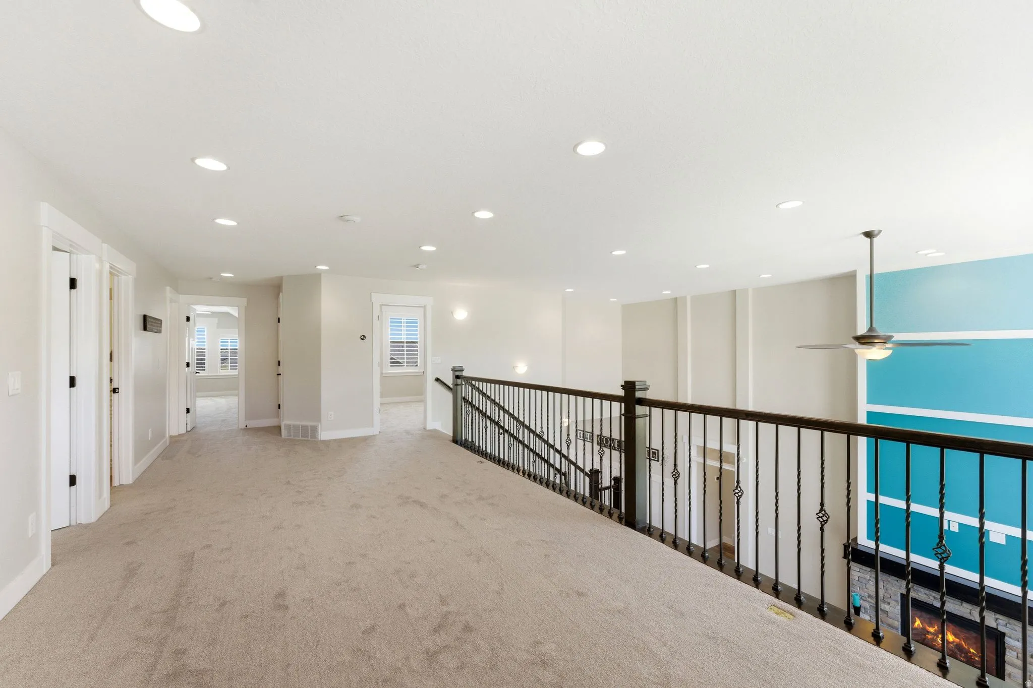 Spacious loft area featuring light-toned carpeting and recessed lighting