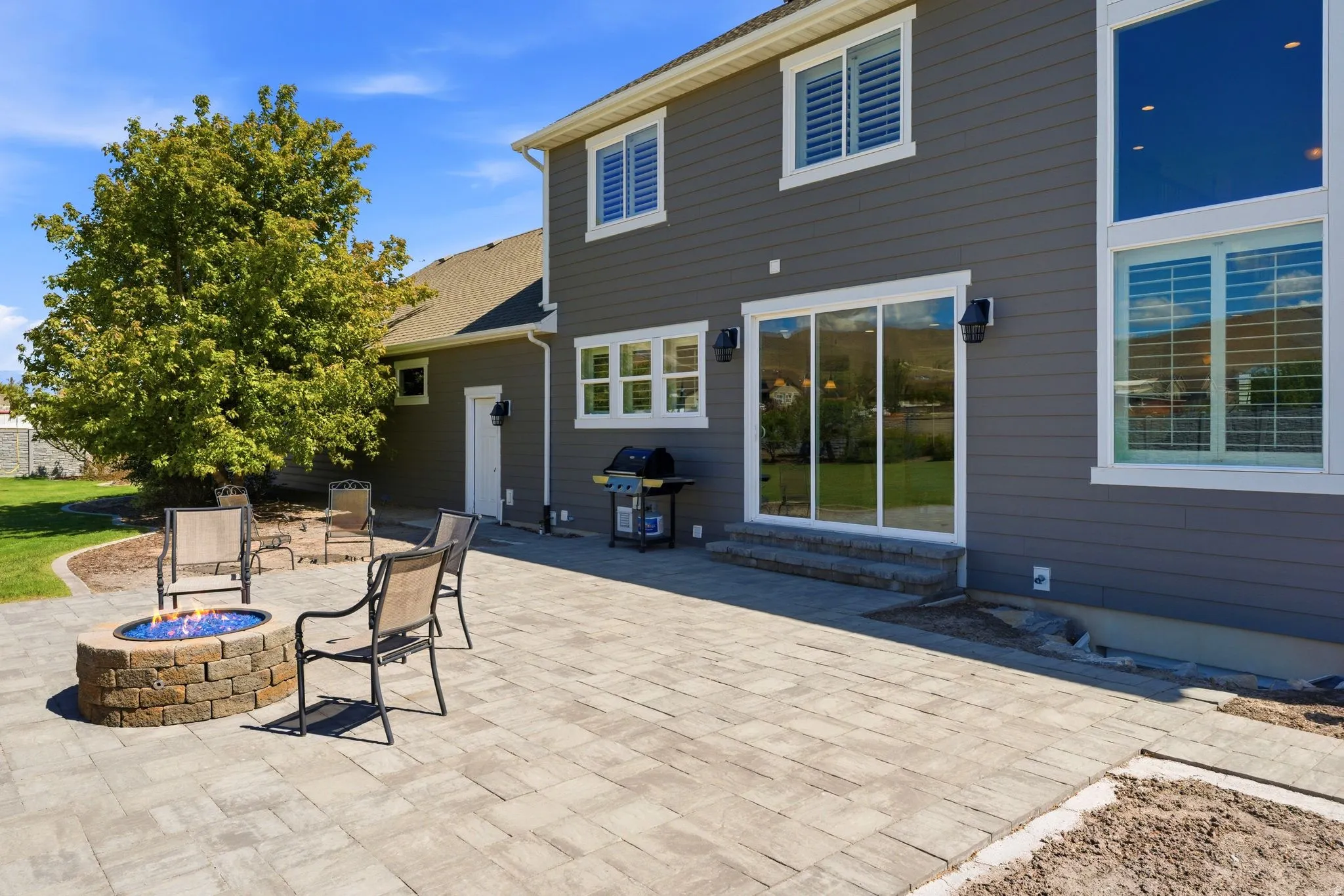 Expansive paver patio with a built-in stone fire pit