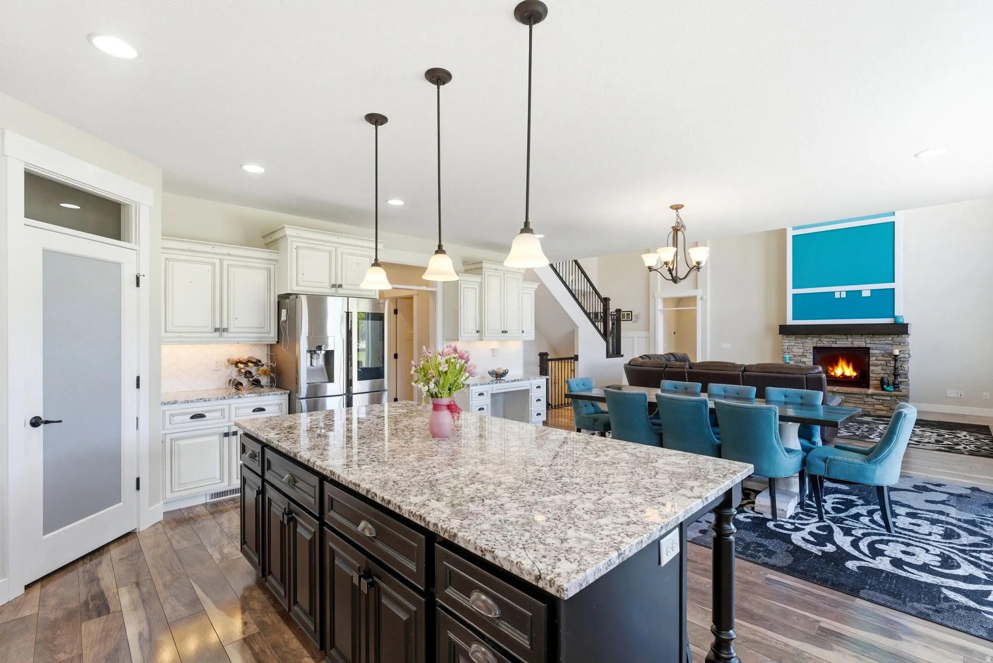 Kitchen featuring a large island with a stone countertop, dark cabinetry, and pendant lighting