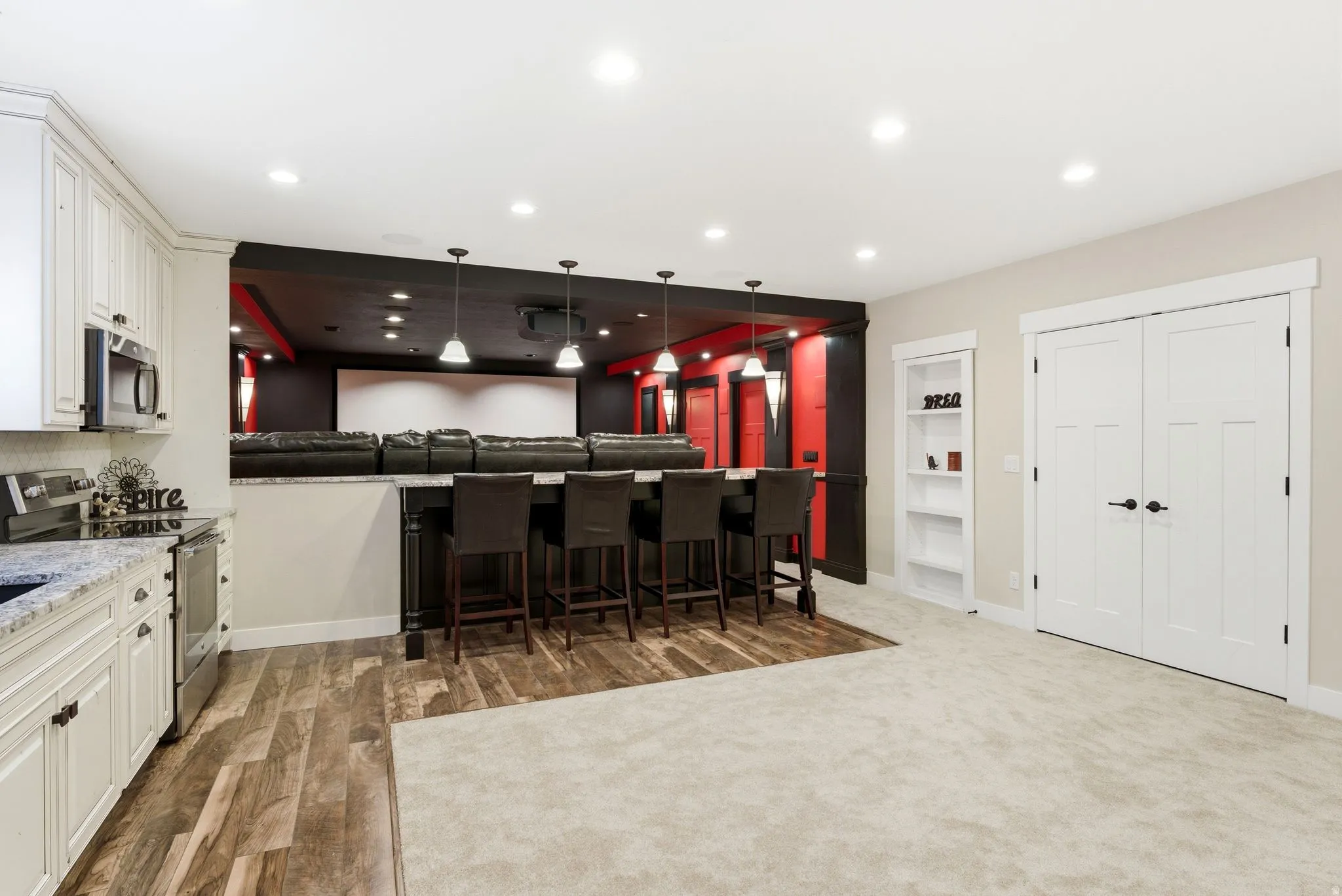 Expansive entertainment space featuring a home theater, wet bar, and kitchenette