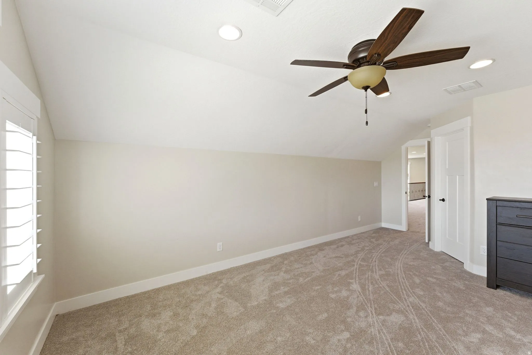 Carpeted room featuring a ceiling fan with integrated lighting, recessed lighting, white baseboards, and white plantation shutters