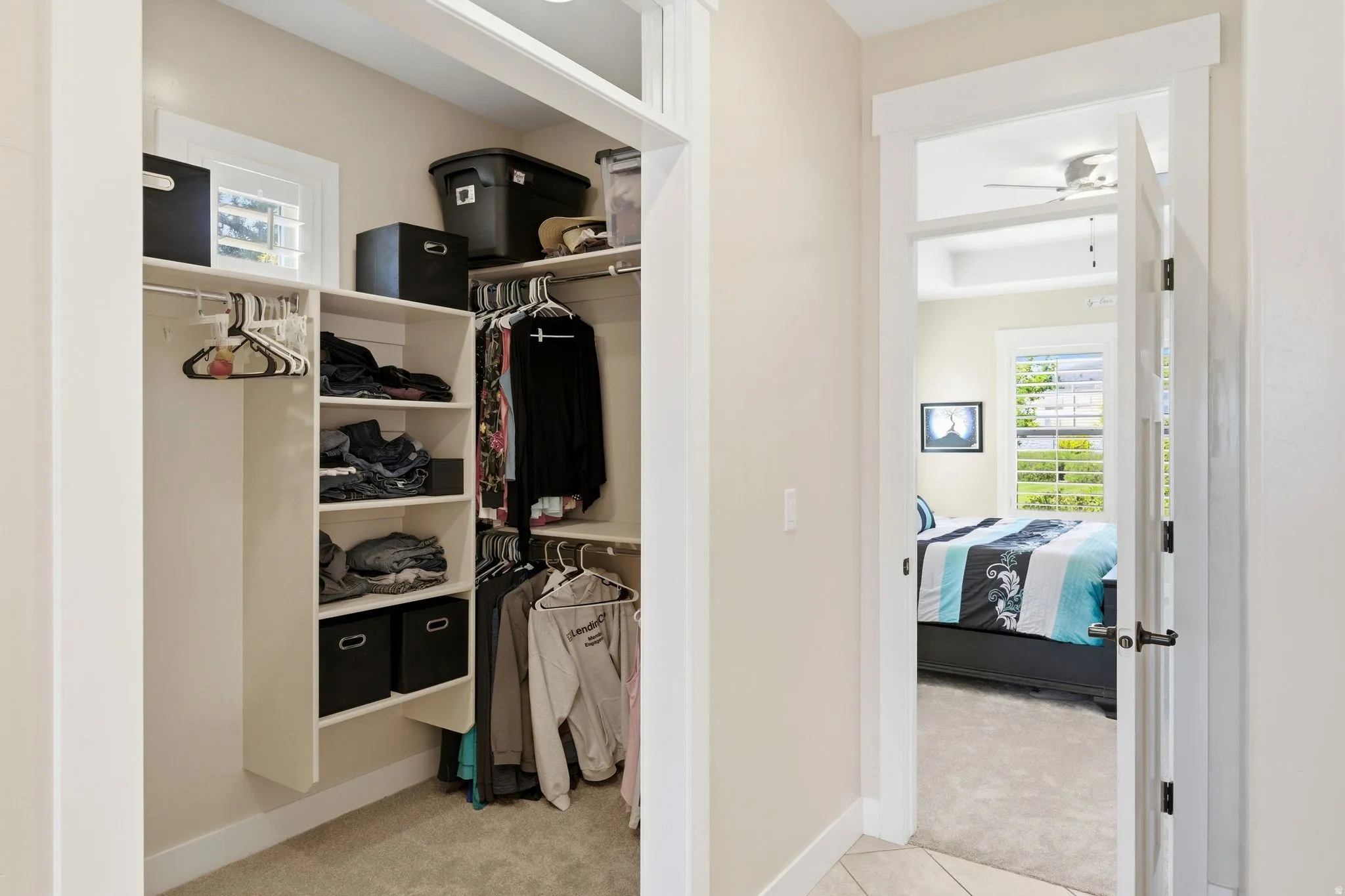 Walk-in closet with built-in shelving, hanging rods, and a window for natural light