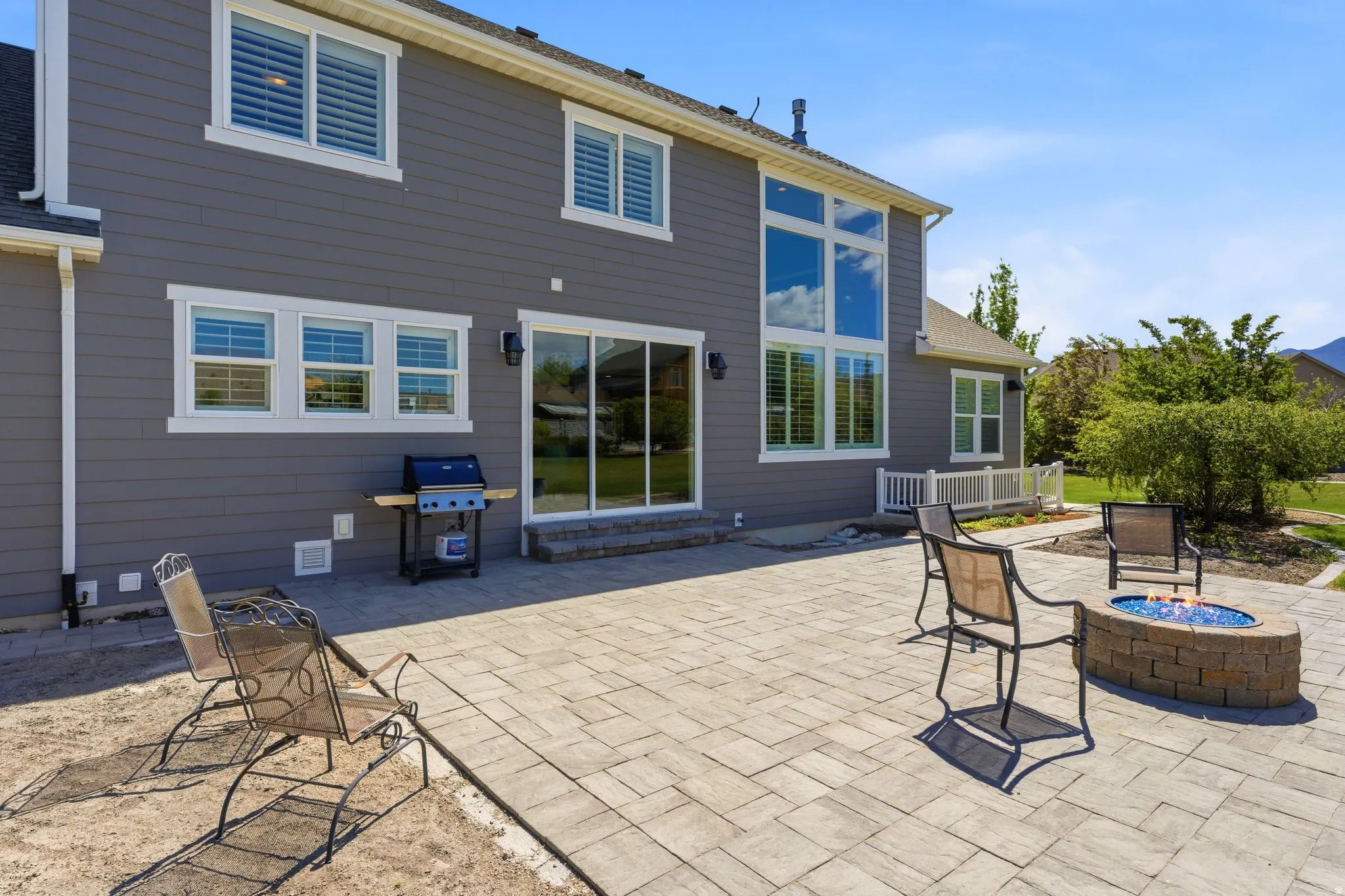 Expansive paver patio featuring a built-in stone fire pit