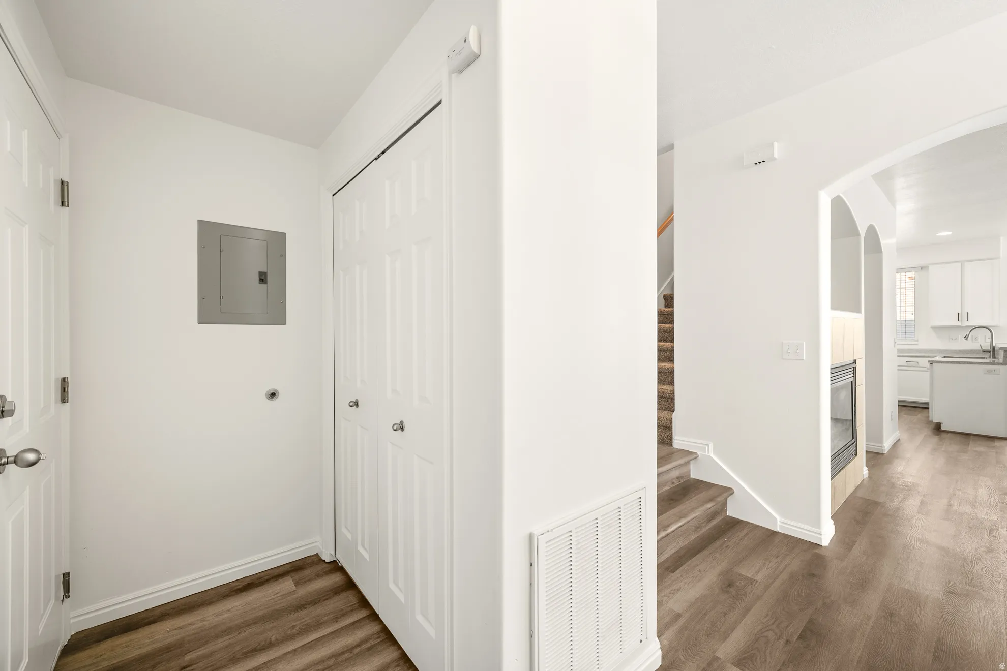 Entryway featuring wood-finish flooring, a bi-fold closet, and a staircase with carpeted treads