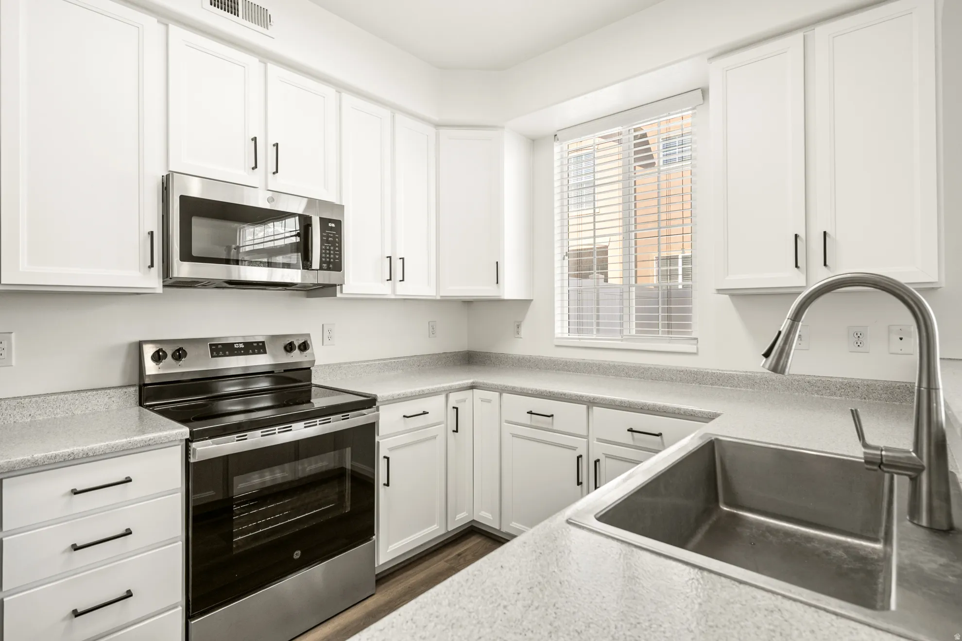 Modern kitchen with white cabinetry and dark hardware