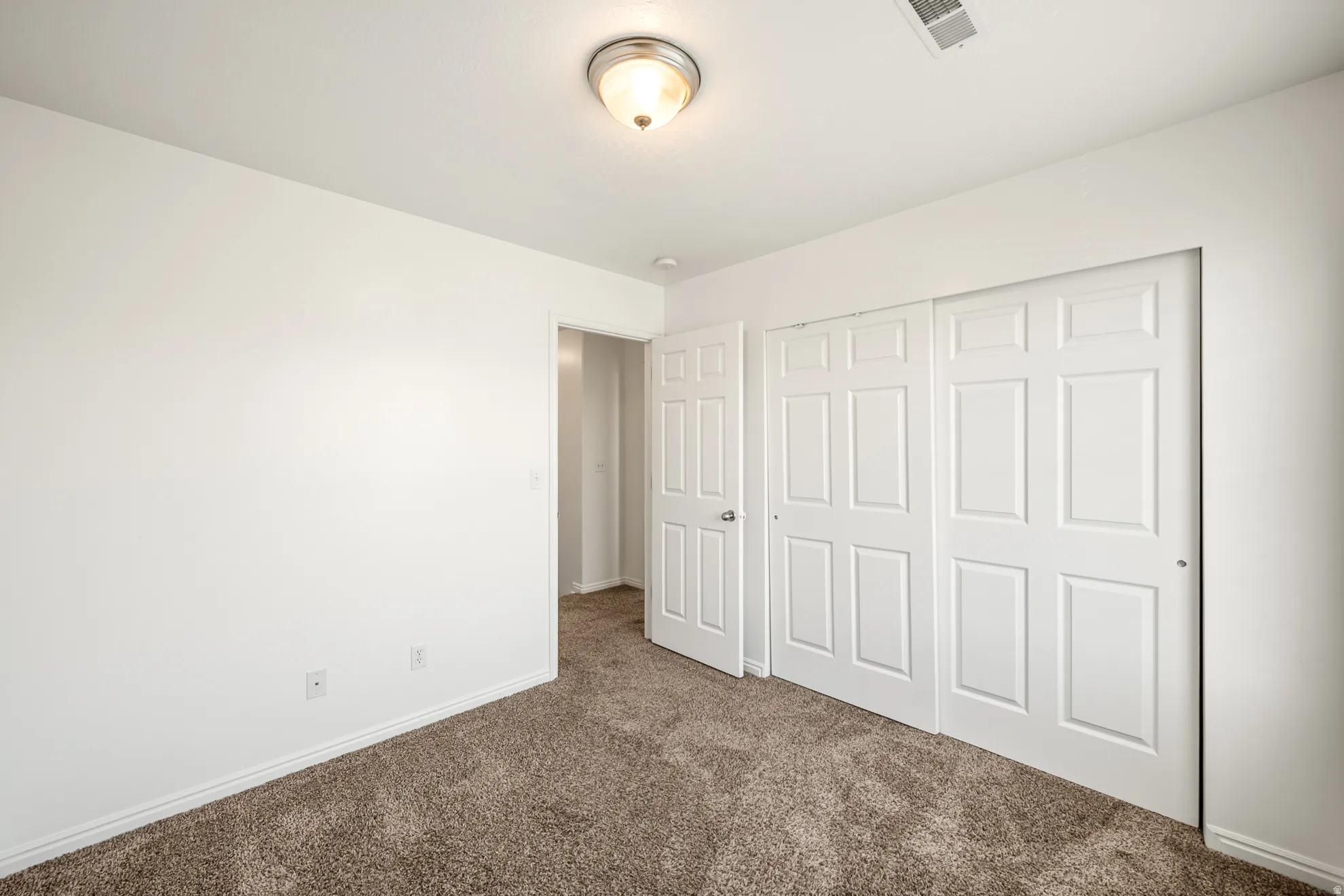 Room featuring light brown carpet, white walls, and white trim