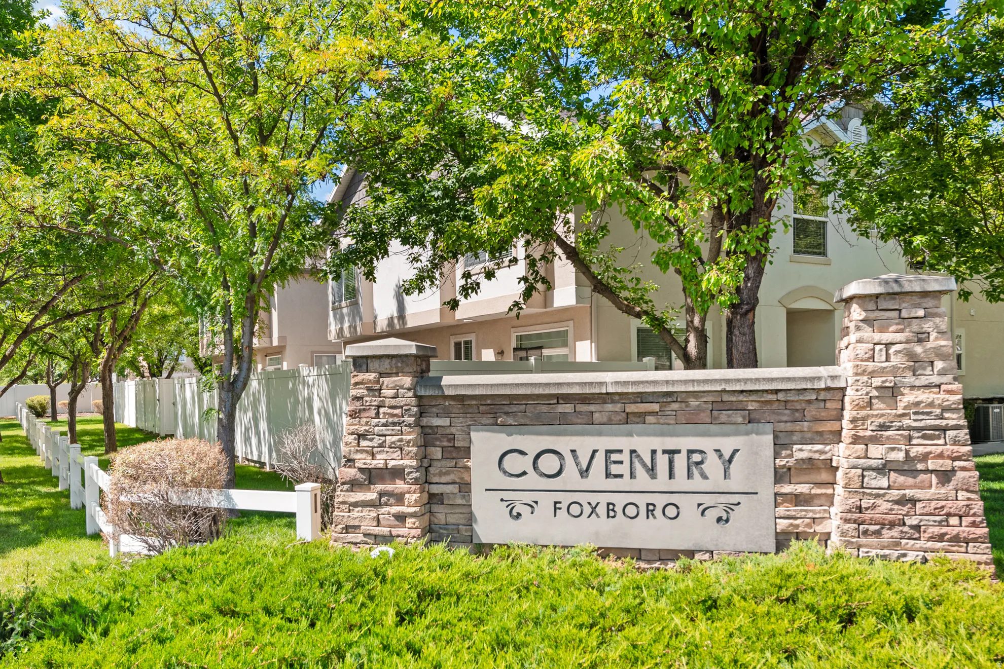Entry monument featuring stacked stone and a carved concrete sign
