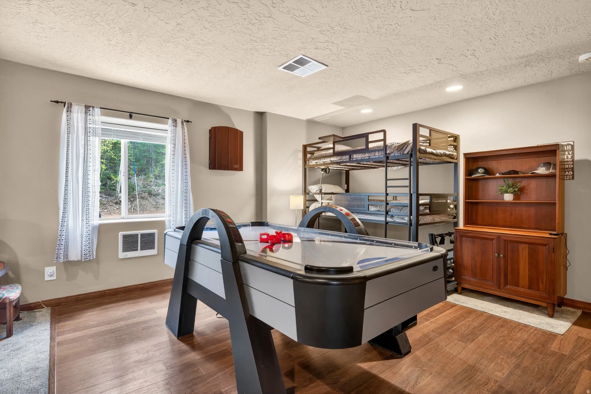 Recreation room with wood-finish flooring and recessed lighting